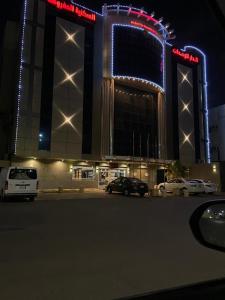 a large building with cars parked in a parking lot at night at Golden New Al Dar - جولدن نيو الدار in Jazan