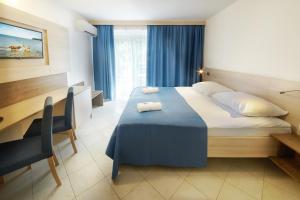 安卡蘭的住宿－Villa Bor - Hotel & Resort Adria Ankaran，配有一张床和一张书桌的酒店客房