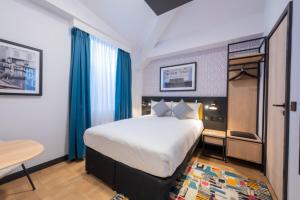 a hotel room with a large bed and a table at The Wesley Camden Town in London