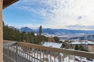 uma varanda com vista para as montanhas cobertas de neve em L'Oree du Bois em Font-Romeu