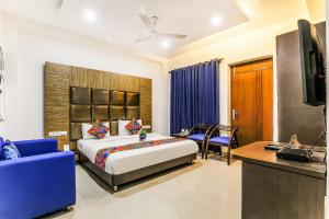 una camera d'albergo con un letto, un divano e una televisione di FabHotel The Residency DLF Galleria a Gurgaon