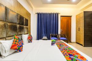 a hotel room with a bed and blue curtains at FabHotel The Residency DLF Galleria in Gurgaon