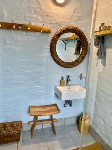 a bathroom with a sink and a mirror and a stool at Bauhinia Beach Loft in Wilderness