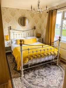 a bedroom with a bed with yellow sheets and a mirror at Immaculate 3-Bedroom Private Lodge near York in York