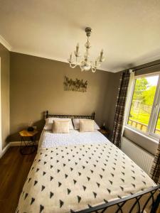 a bedroom with a bed and a chandelier at Immaculate 3-Bedroom Private Lodge near York in York