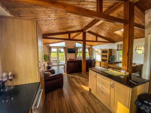 Una cocina y sala de estar con techos de madera. en Immaculate 3-Bedroom Private Lodge near York, en York