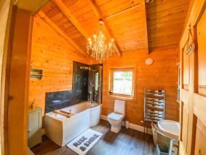 a bathroom with a tub and a toilet and a chandelier at Beautiful 3-Bed Luxury Private Lodge in York in York +22 photos