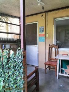 een keuken met een koelkast, een tafel en een stoel bij Small House - Baguio in Baguio