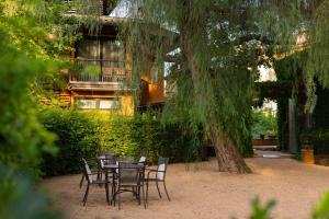 una mesa y sillas bajo un árbol frente a un edificio en Hotel Mas La Boella, en La Canonja