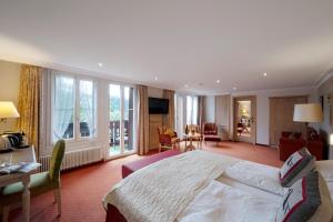 グリンデルワルトにあるロマンティック ホテル シュヴァイツァーホフのベッドルーム(大型ベッド1台付)、リビングルームが備わります。