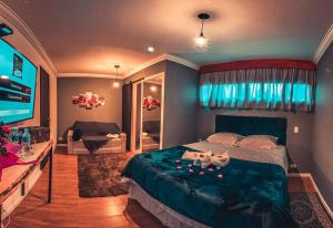 a bedroom with a large bed and a television at Tico Pousada - Campos do Jordão in Campos do Jordão