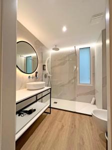 a bathroom with a shower and a sink and a mirror at Soho Boutique Turia in Valencia