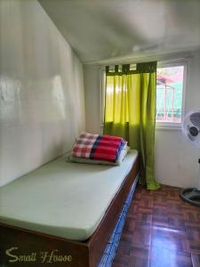 a bed in a small house with a window at Small House - Baguio in Baguio