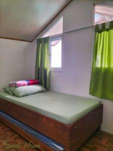 a bed in a small room with a window at Small House - Baguio in Baguio