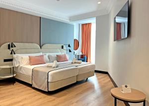 1 dormitorio con 1 cama grande y 1 mesa en Soho Boutique Turia, en Valencia