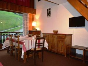 a dining room with a table with chairs and a television at Appartement Le Grand-Bornand, 1 pièce, 6 personnes - FR-1-241-5 in Le Grand-Bornand