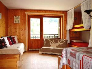 1 dormitorio con 2 camas, ventana y silla en Appartement Le Grand-Bornand, 1 pièce, 4 personnes - FR-1-241-116, en Le Grand-Bornand