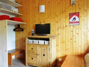 Habitación con TV en una pared de madera. en Appartement Le Grand-Bornand, 1 pièce, 4 personnes - FR-1-241-116, en Le Grand-Bornand