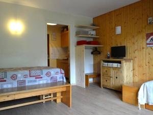 1 dormitorio con 1 cama y TV. en Appartement Le Grand-Bornand, 1 pièce, 4 personnes - FR-1-241-116, en Le Grand-Bornand