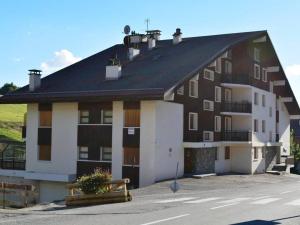 un gran edificio marrón y blanco con techo negro en Appartement Le Grand-Bornand, 1 pièce, 4 personnes - FR-1-241-116, en Le Grand-Bornand