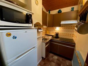 a kitchen with a white refrigerator and a microwave at Appartement Le Grand-Bornand, 2 pièces, 6 personnes - FR-1-241-120 in Le Grand-Bornand