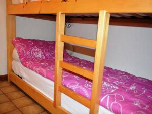 a bunk bed with a bunk bed with purple sheets at Appartement Le Grand-Bornand, 2 pièces, 6 personnes - FR-1-241-11 in Le Grand-Bornand
