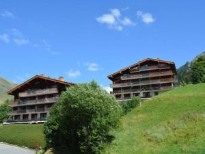 ル・グラン・ボルナンにあるAppartement Le Grand-Bornand, 2 pièces, 6 personnes - FR-1-241-120の木の横の丘の上の二棟