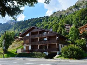 a building on a hill with a mountain at Appartement Le Grand-Bornand, 2 pièces, 6 personnes - FR-1-241-11 in Le Grand-Bornand