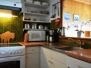a kitchen with a sink and a stove and a microwave at Appartement Le Grand-Bornand, 2 pièces, 5 personnes - FR-1-241-101 in Le Grand-Bornand