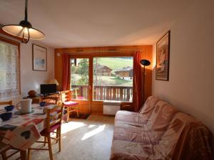 a living room with a table and a view of a balcony at Appartement Le Grand-Bornand, 2 pièces, 6 personnes - FR-1-241-17 in Le Grand-Bornand