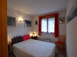 a bedroom with a bed and a window and a chair at Appartement Le Grand-Bornand, 2 pièces, 6 personnes - FR-1-241-17 in Le Grand-Bornand