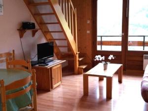 a living room with a television and a staircase at Appartement Le Grand-Bornand, 2 pièces, 6 personnes - FR-1-241-21 in Le Grand-Bornand