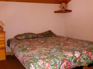 a bedroom with a bed with a floral bedspread at Appartement Le Grand-Bornand, 2 pièces, 6 personnes - FR-1-241-21 in Le Grand-Bornand