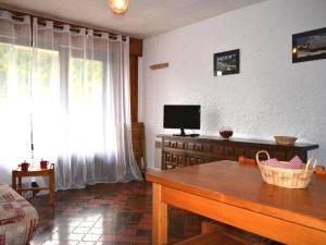 a living room with a table and a television at Appartement Le Grand-Bornand, 1 pièce, 4 personnes - FR-1-241-126 in Le Grand-Bornand