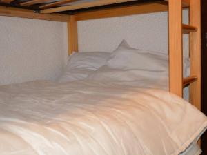a bed with white sheets and pillows on it at Appartement Le Grand-Bornand, 1 pièce, 4 personnes - FR-1-241-126 in Le Grand-Bornand