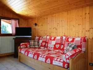 a living room with a red couch in a cabin at Appartement Le Grand-Bornand, 2 pièces, 6 personnes - FR-1-241-94 in Le Grand-Bornand