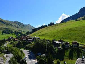 a village in a green hill with a road at Appartement Le Grand-Bornand, 2 pièces, 6 personnes - FR-1-241-94 in Le Grand-Bornand