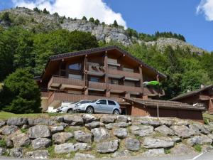 un coche aparcado frente a una casa con una montaña en Studio Le Grand-Bornand, 1 pièce, 4 personnes - FR-1-241-109, en Le Grand-Bornand