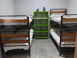 a room with three bunk beds and a green cabinet at Alarpe Aterpetxea in Zaldivia