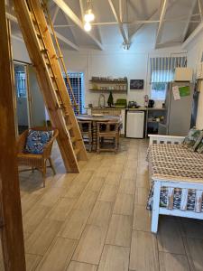 a living room with a staircase and a kitchen at Bauhinia Beach Loft in Wilderness