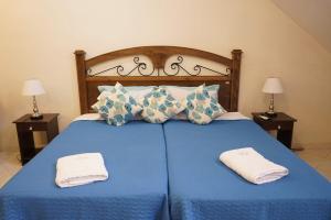 Una cama azul con dos toallas encima. en Sol de Luque Casa-hotel, en Luque