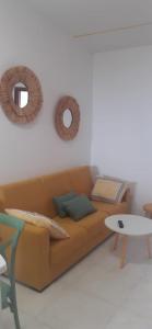 a living room with a couch and a table and mirrors at Apartamentos Puerto de Aguiño in Couso