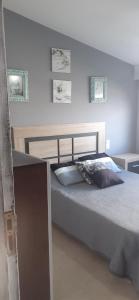 a bedroom with a bed and two pictures on the wall at Apartamentos Puerto de Aguiño in Couso