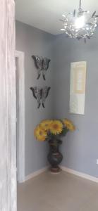 a room with butterflies on the wall and a vase with flowers at Apartamentos Puerto de Aguiño in Couso