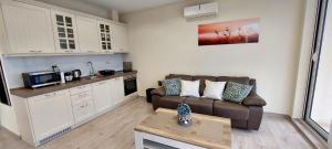 ein Wohnzimmer mit einem Sofa und einer Küche in der Unterkunft Bay of Kotor View Apartment with pool in Prčanj