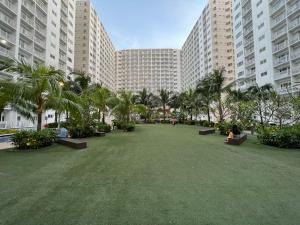 a large park with palm trees and buildings at Yam Staycation Shore Residences in Manila