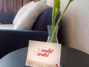 ein Schild auf einem Tisch mit einer Vase mit einer Blume in der Unterkunft ibis Styles Den Haag Scheveningen in Scheveningen
