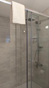 um chuveiro com uma porta de vidro e uma toalha em Casa Domingues Guest House nas Caldas da Rainha