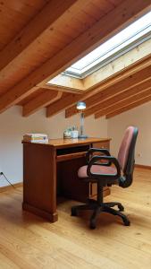 un bureau mansardé avec un bureau et une chaise dans l'établissement Casa Domingues Guest House, à Caldas da Rainha