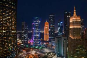 Blick auf die Skyline der Stadt in der Nacht in der Unterkunft Wyndham Doha West Bay in Doha